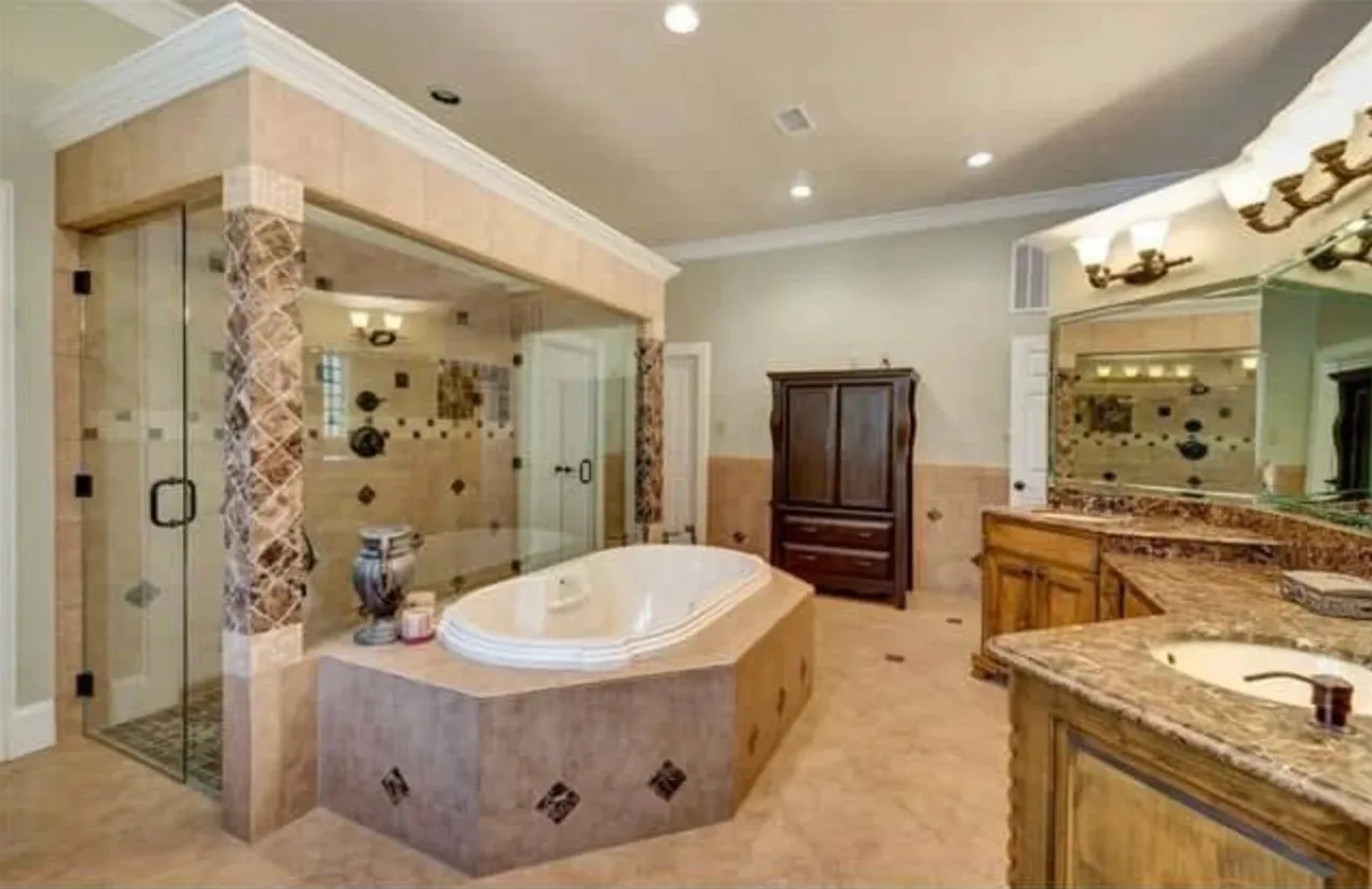 Primary bathroom with a glass walk-in shower, a tiled garden tub and a marble double vanity
