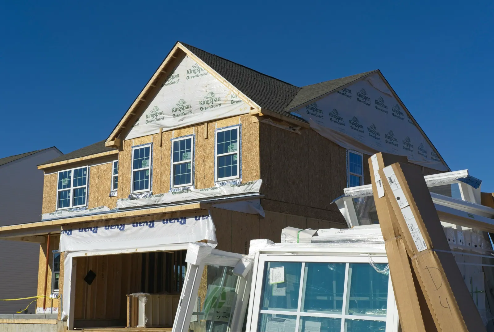 New two-storey framing wrapped in sheathing, windows stacked in front